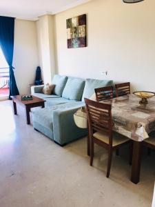 a living room with a blue couch and a table at Princesa Kristina in Manilva
