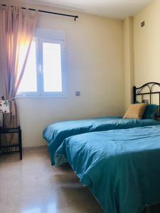 two beds in a room with a window at Princesa Kristina in Manilva