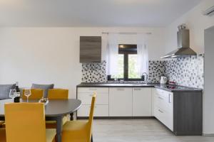 kuchnia ze stołem i żółtymi krzesłami w obiekcie Apartments Antica - Edita w mieście Rtina