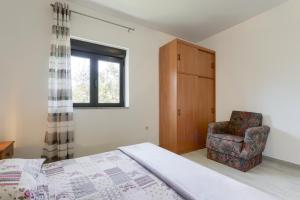 una camera con un letto e una sedia e una finestra di Apartments Antica - Edita a Rtina