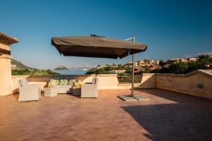 a patio with chairs and an umbrella on a roof at Villaggio Perlacea in Golfo Aranci