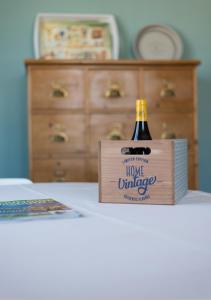 una botella de vino en una caja de madera sobre una mesa en La Source, en Hermanville-sur-Mer
