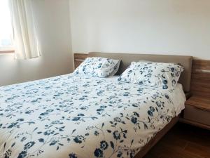 a bed with blue and white sheets and pillows at Apartment Vrenjak in Portorož