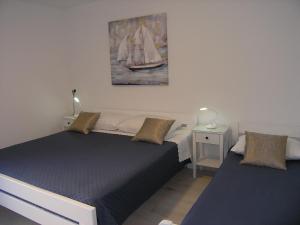ein Schlafzimmer mit 2 Betten und einem Wandgemälde in der Unterkunft Vlasta in Mali Lošinj