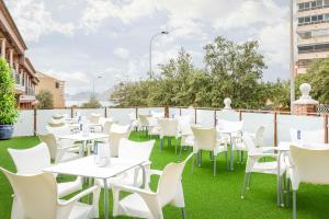 a row of tables and white chairs on a patio at Hotel Boutique Calas de Alicante in Alicante