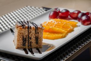 a plate of food with a piece of cake and fruit at Hotel Boutique Calas de Alicante in Alicante