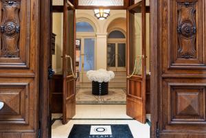 un couloir avec des portes en bois et un vase de fleurs dans l'établissement Le Camp Suite & Spa, à Padoue