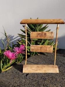 a wooden bench with two signs that sayres wanted at Pés Verdes-Alojamento e Chá in Ponta Delgada