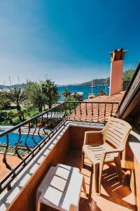 a balcony with two chairs and a view of the water at Gocek Unlu Hotel in Göcek