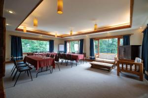 Petrohue Lodge في بيتروهي: غرفة كبيرة بها طاولات وكراسي ونوافذ