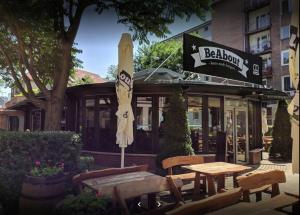 une table, des chaises et un parasol devant un restaurant dans l'établissement City Lights Apartment with Terrace - 24 Hours Check in, à Bratislava