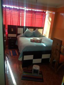 um quarto com uma cama grande e uma janela vermelha em Hostal "Oro Blanco" em Uyuni