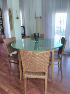 une table en verre avec des chaises et un vase au-dessus dans l'établissement Cozy Penthouse, à Thessalonique