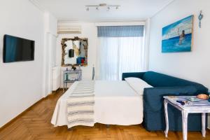 a living room with a blue couch and a tv at Coastal Apartment Palaio Faliro in Athens