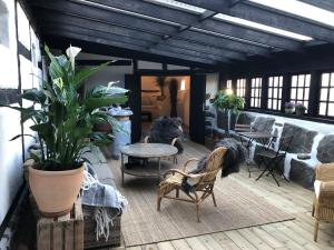 eine Terrasse mit Stühlen, einem Tisch und Stühlen in der Unterkunft Rubensholm Bed & Breakfast in Brösarp