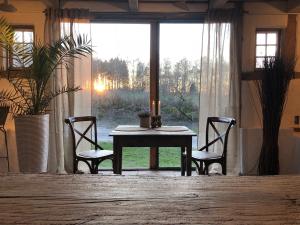 einen Tisch und zwei Stühle in einem Zimmer mit Fenster in der Unterkunft Rubensholm Bed & Breakfast in Brösarp