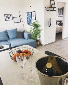 een keuken met een tafel met wijnglazen en een kom sinaasappels bij EllaVis Apartments in Vis