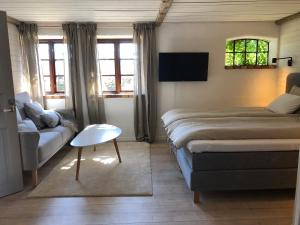 Pokój z dwoma łóżkami, kanapą i telewizorem w obiekcie Rubensholm Bed & Breakfast w mieście Brösarp
