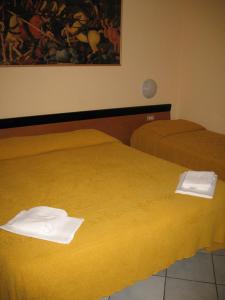 two beds in a hotel room with towels on them at Albergo Paradiso in Montecatini Terme