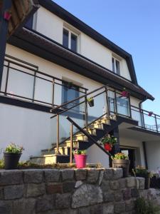 a house with windows and potted plants on a stone wall at Au pied de la dune in Sangatte