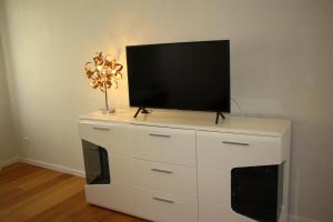 eine weiße Kommode mit einem Fernseher darüber in der Unterkunft Apartment NUMBER 5 in Wien