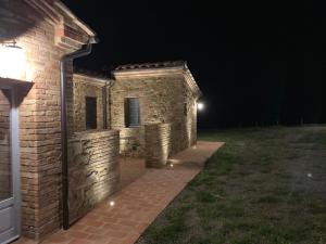 a brick building at night with a light on it at Cordella In Valdorcia Truffle and Olive Oil Resort in Montalcino