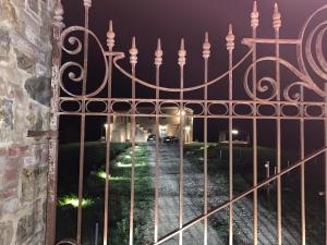 a gate in front of a building at night at Cordella In Valdorcia Truffle and Olive Oil Resort in Montalcino