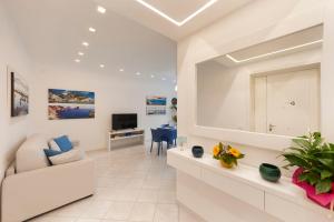 a living room with a white couch and a television at Casa Aurora in Sorrento