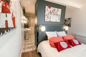 a bedroom with a bed with red and white pillows at Le Clos de la Pointe Saint-Mathieu in Plougonvelin