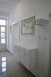 a kitchen with white cabinets and a picture on the wall at Sesar Apartments Krk - No. 1 Iva in Krk