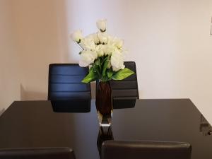 un vaso di fiori bianchi seduto su un tavolo di Deluxe Eleanna a Nea Kalikratia
