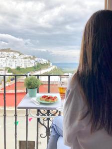 una mujer sentada en una mesa con una copa de vino en Casa El Patio, en Vejer de la Frontera