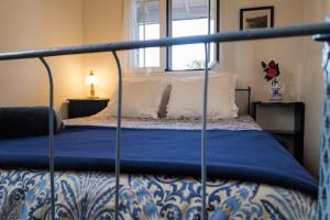 a bed with a blue and white bedspread and a window at Casa da Canada in Ribeira Grande