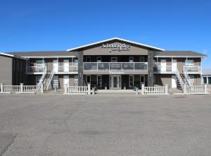 a large building with a parking lot in front of it at Arbour Ridge Inn & Suites in Kindersley