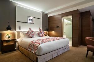 a hotel room with a bed, chair, and nightstand at Movenpick Hotel & Convention Centre KLIA in Sepang