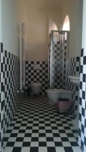 La salle de bains est pourvue d'un sol en damier noir et blanc. dans l'établissement Villa Martelli, à Belgirate