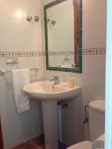 bagno con lavandino, specchio e servizi igienici di Casa O Fabal a Fabal