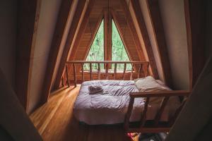 Bett in einem Zimmer mit einem großen Fenster in der Unterkunft Puente Palos San Pedro in Castro