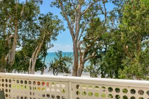 a fence with trees and the ocean in the background at Hibiscus in Marlin Waters Palm Cove in Palm Cove