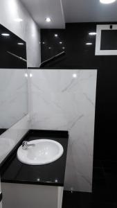 a bathroom with a white sink and a black counter at Vista Atlântico in Gaula