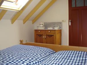 1 dormitorio con 1 cama blanca y azul a cuadros en 't Kruushuus, en Welsum