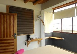 a room with a window with a blind on it at La Facha Hostal Restaurant Surf in Mompiche