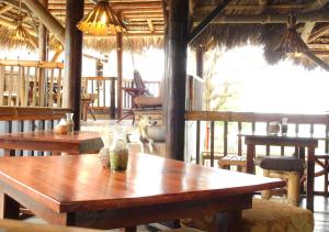 a dining room with wooden tables and chairs at La Facha Hostal Restaurant Surf in Mompiche