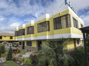 塔巴貝拉的住宿－Hostal Mariscal Sucre，黄色和白色的建筑,上面有标志