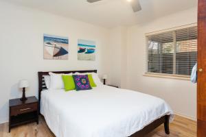 a white bedroom with a bed and a window at Bella vista in Maslin Beach