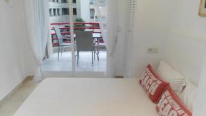 Cette chambre dispose d'un lit et d'un balcon avec une table. dans l'établissement Azul Rentals Albir flat, à Albir