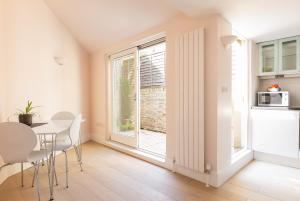 a kitchen and dining room with a table and a window at Apartment with Private PATIO, and PARK across the road in London
