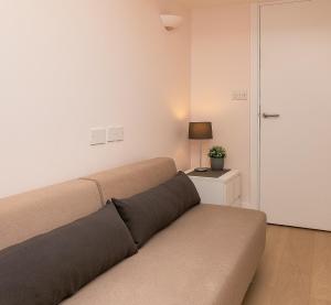 a couch sitting in a living room with a lamp at Apartment with Private PATIO, and PARK across the road in London