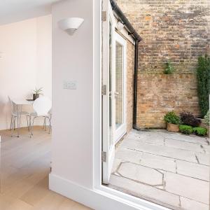 an open door in a room with a brick wall at Apartment with Private PATIO, and PARK across the road in London