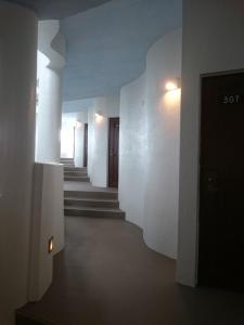 un pasillo con paredes blancas y escaleras en un edificio en Eef Condominium Kumejima, en Kumejima